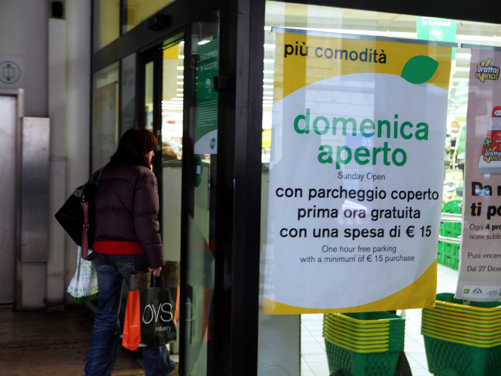 Un negozio segnala con grande evidenza l’apertura domenicale: ma su questa opportunità è scontro fra le categorie del commercio FOTO MARCHIORI    